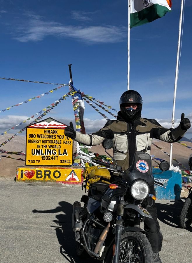 Rider with thumbs up beside the Umling La 19,024 ft sign